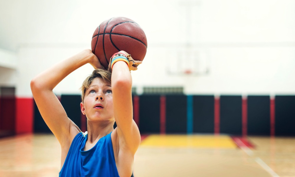 young boy practicing shooting a basketball