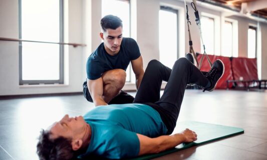 Man working with a personal trainer at a gym